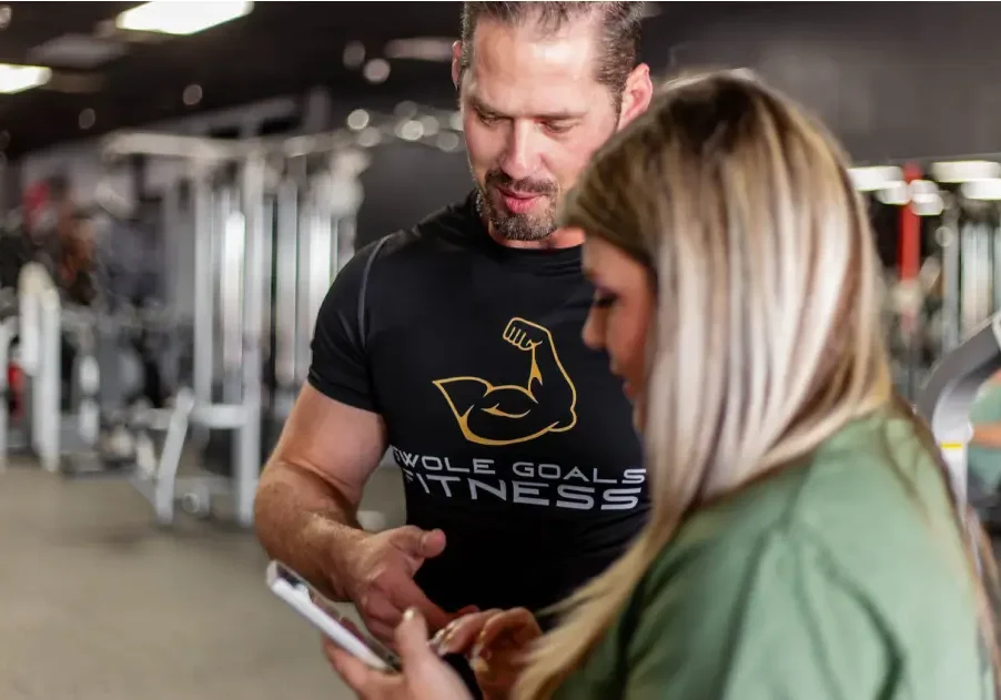 Fitness coach reviewing client progress on mobile app