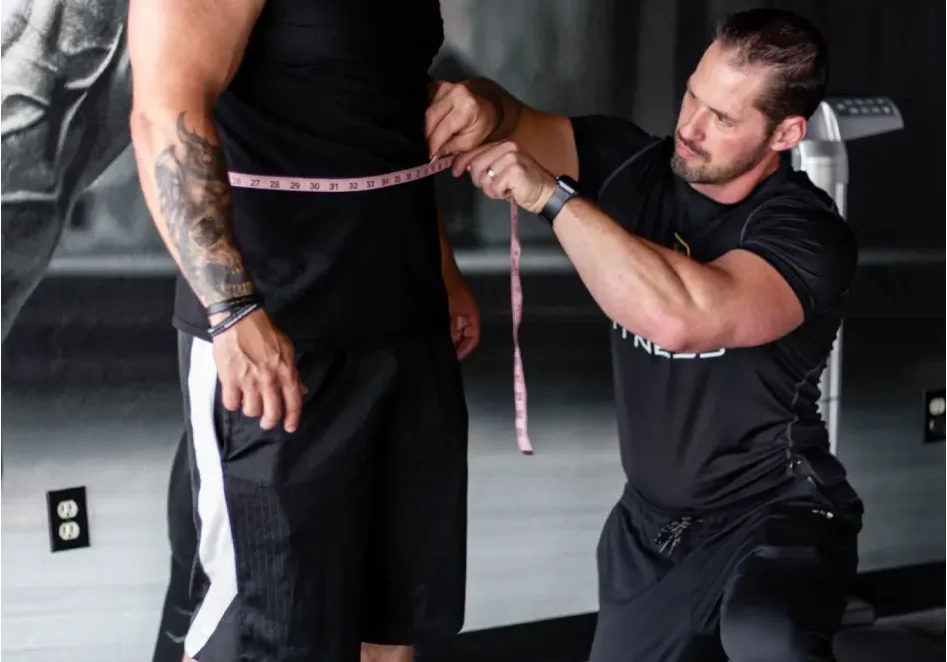 Personal trainer conducting body composition assessment for bodybuilding client